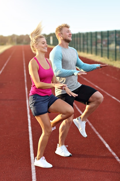 uomo e donna che corrono su pista all'aperto