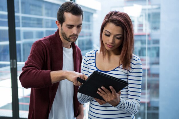 Uomo e donna che discutono sulla tavoletta digitale