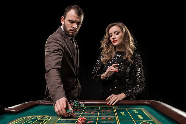 Uomo e donna che giocano al tavolo della roulette nel casinò