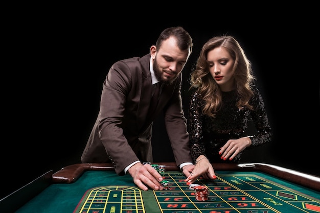 Uomo e donna che giocano al tavolo della roulette nel casinò