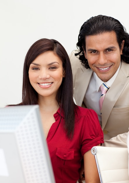 Uomo e donna che lavorano insieme sorridendo alla telecamera