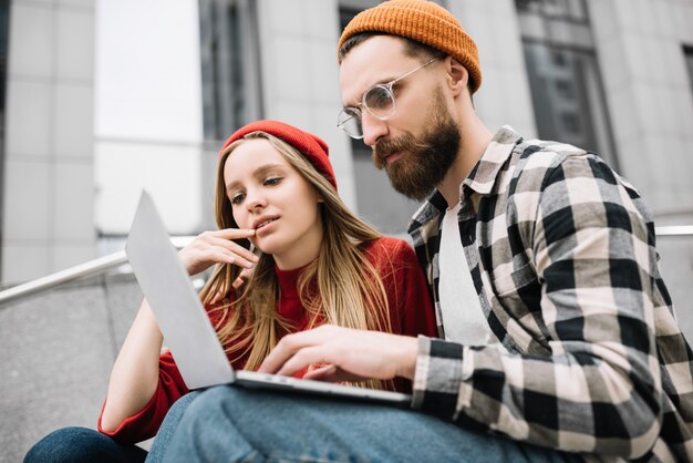 Uomo e donna che per mezzo del computer portatile, lavorando insieme, pianificando l'avvio