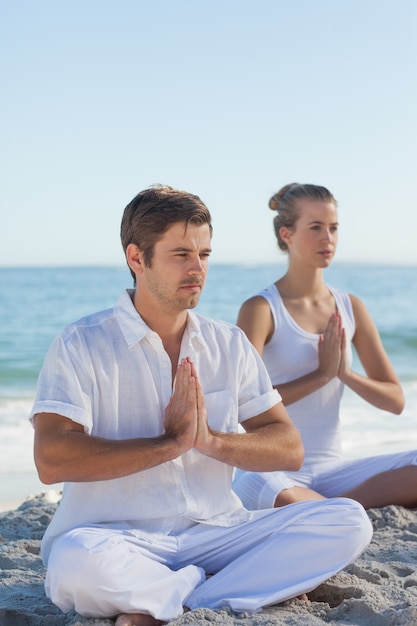 Uomo e donna che praticano yoga