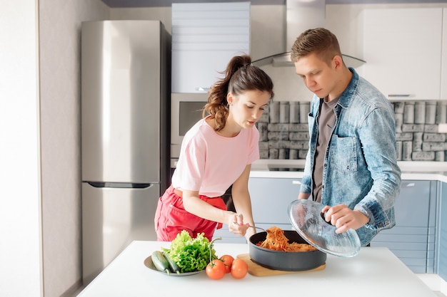 Uomo e donna che preparano la pasta in cucina a casa