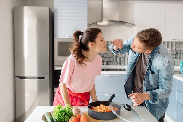 Uomo e donna che preparano la pasta in cucina a casa