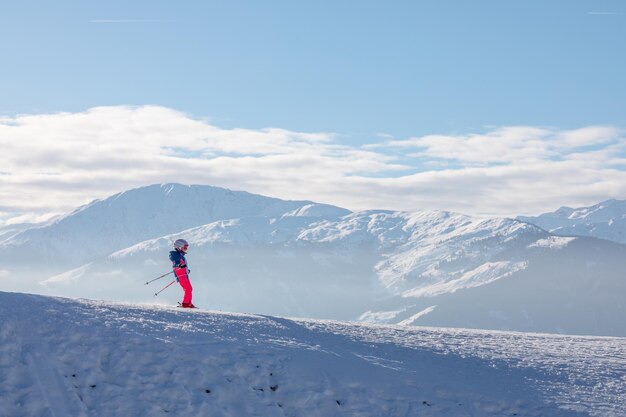 Uomo e donna che sciano e fanno snowboard nella stazione sciistica di montagna