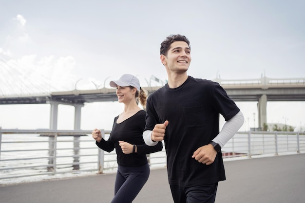 Uomo e donna che si allenano in esecuzione nel parco Bracciale fitness orologio sul braccio Una coppia felice