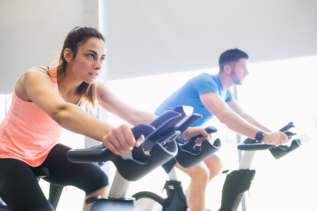 Uomo e donna che utilizzano cyclette da ciclismo