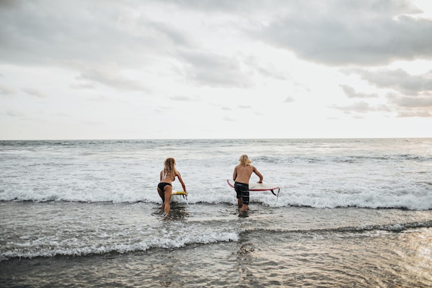 Uomo e donna che vanno a fare surf