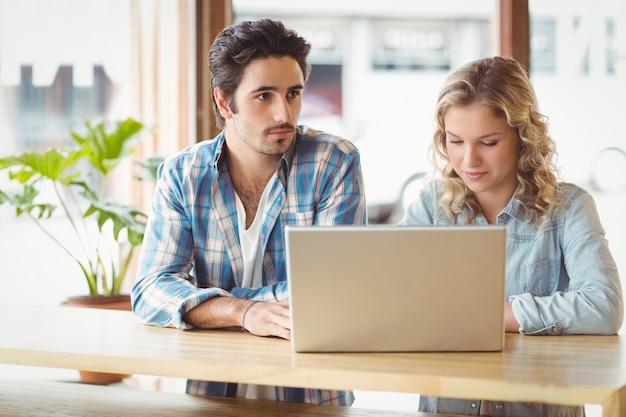 Uomo e donna con il portatile seduto in ufficio