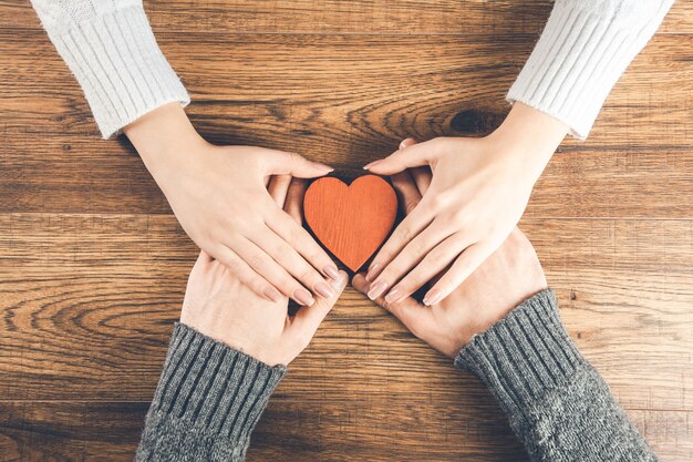 Uomo e donna con piccolo cuore su legno