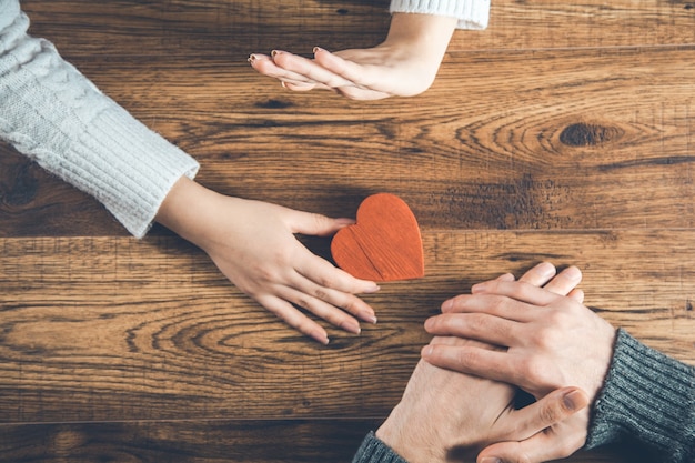 Uomo e donna con piccolo cuore su legno