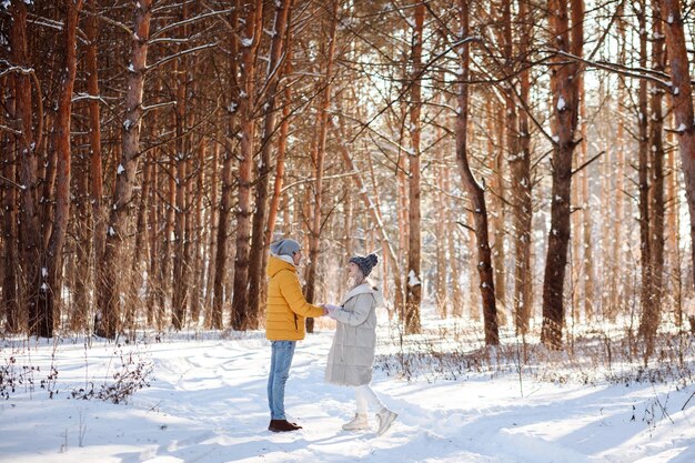 Uomo e donna in abiti caldi nella foresta invernale all'aperto