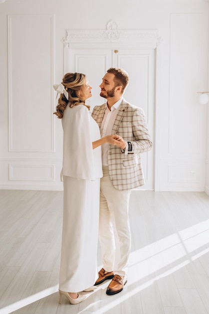 uomo e donna in abiti da sposa il giorno del matrimonio insieme in un interno luminoso