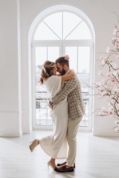 uomo e donna in abiti da sposa il giorno del matrimonio insieme in un interno luminoso