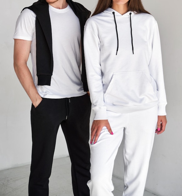 Uomo e donna in piedi in felpe bianche mock up per il marchio di abbigliamento