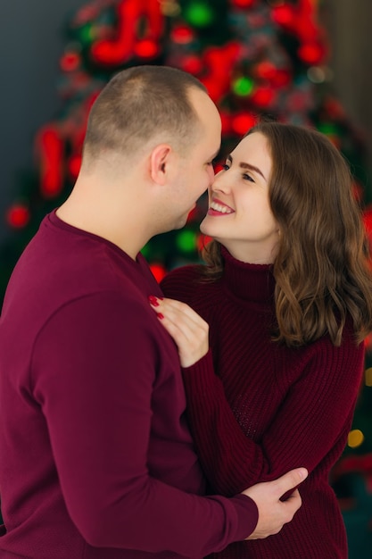 Uomo e donna in piedi vicino all'albero di Natale