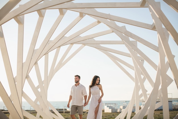 Uomo e donna in posa. Strutture geometriche in legno. La sposa e lo sposo.