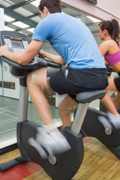 Uomo e donna in sella a una cyclette