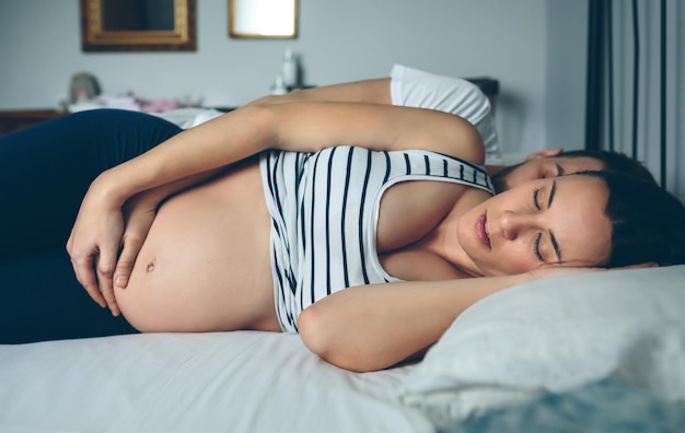 Uomo e donna incinta che dormono a letto