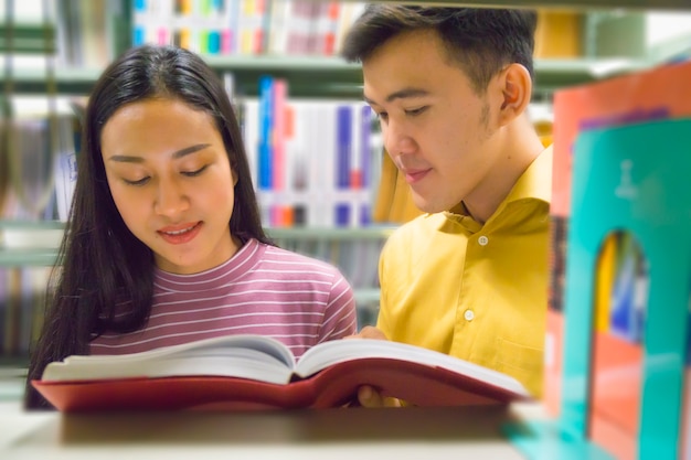 uomo e donna leggono e parlano di libro aperto allo scaffale