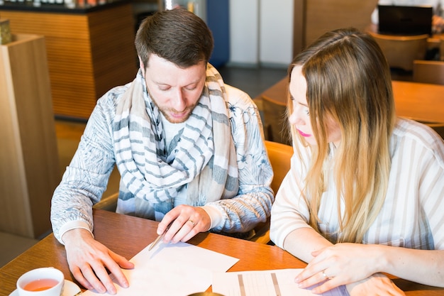 Uomo e donna liberi professionisti che discutono idee e prendono appunti