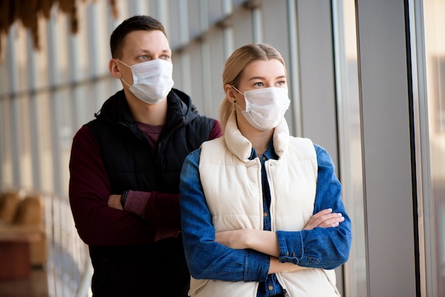 Uomo e donna malati che si sentono male, indossando una maschera protettiva contro le malattie infettive trasmissibili e come protezione contro l'influenza.