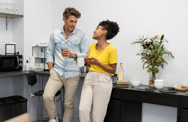 Uomo e donna multirazziali in co-working con caffè