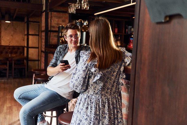 Uomo e donna Persone in abiti casual seduti al pub