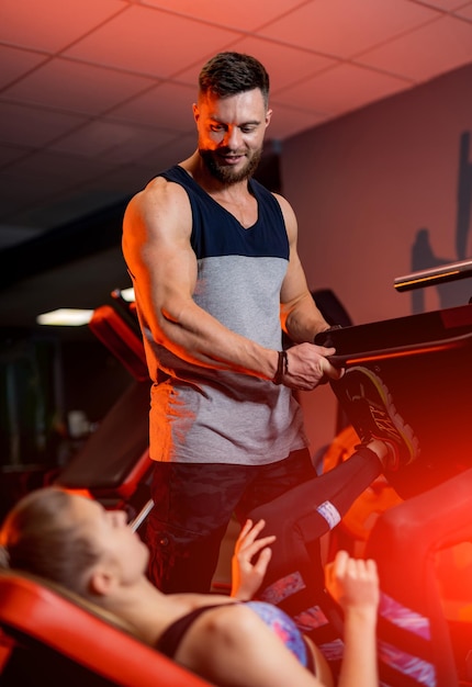 Uomo e donna sportivi che fanno esercizi in palestra contemporanea Il personal trainer conduce un corso sportivo Stile di vita attivo