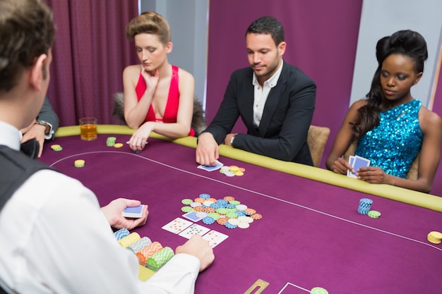 Uomo e due donne che giocano a poker