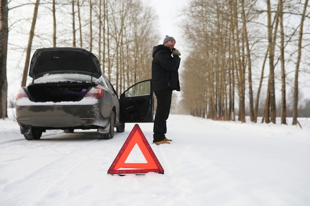 Uomo e macchina. Passeggiata invernale e riparazione auto.