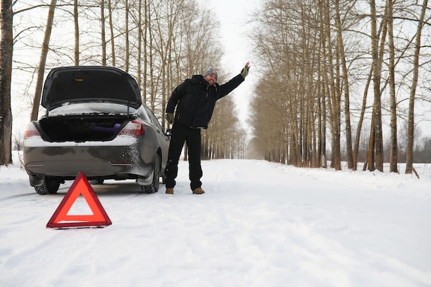 Uomo e macchina. Passeggiata invernale e riparazione auto.