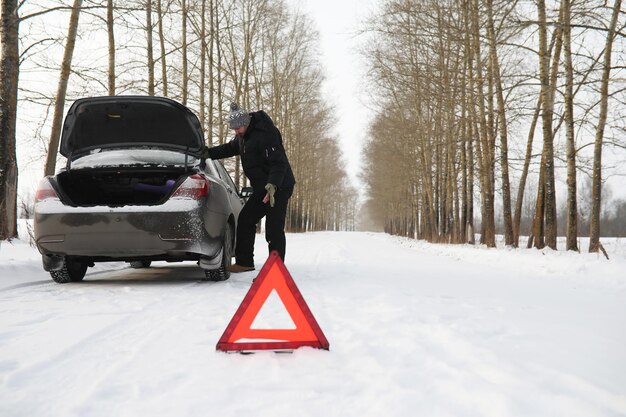 Uomo e macchina. Passeggiata invernale e riparazione auto.