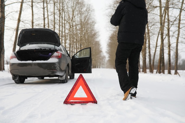 Uomo e macchina. Passeggiata invernale e riparazione auto.