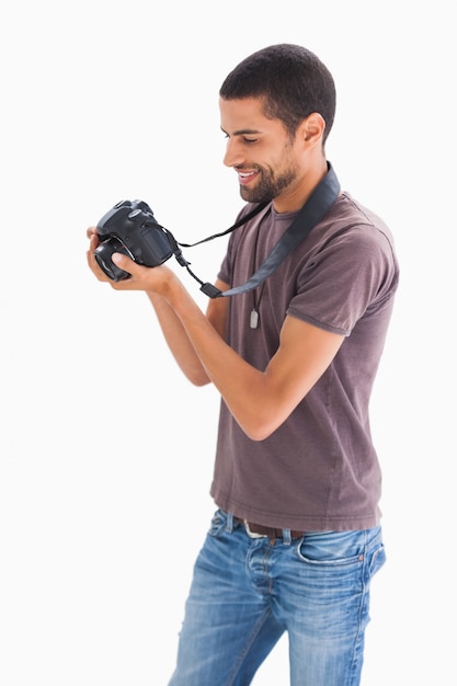 Uomo elegante guardando fotocamera digitale