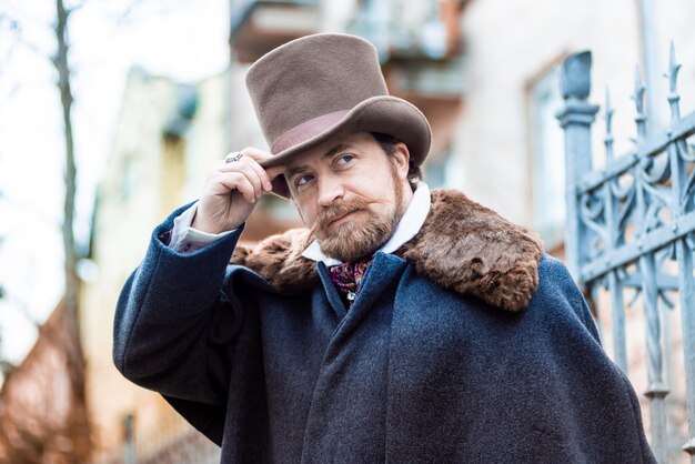 Uomo elegante. Il gentiluomo con un cappotto e un cappello a cilindro