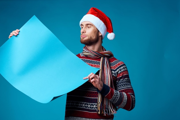 Uomo emotivo in una posa dello studio del manifesto del modello blu di natale