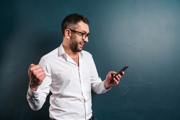 Uomo emozionante con gli occhiali in chat per telefono.