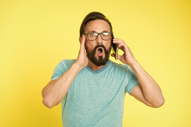 Uomo entusiasta delle opportunità di telefonia mobile Hipster uso allegro dello smartphone Uomo felice utente di uno smartphone moderno Rimani in contatto con lo smartphone moderno Unisciti alla comunità online Concetto di facile utilizzo
