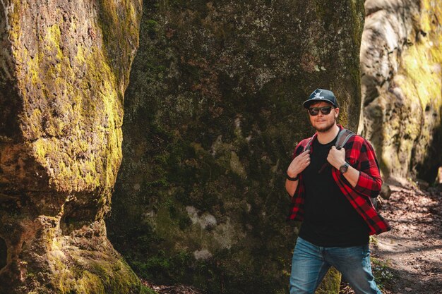 Uomo escursionista con zaino a piedi dal sentiero nel canyon dovbush rocce Ucraina