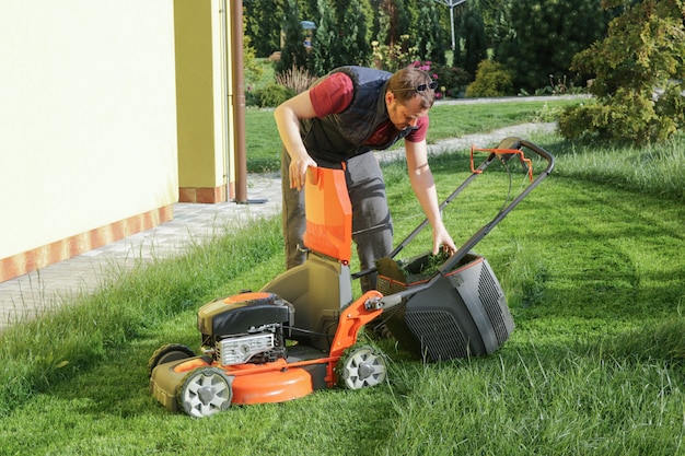 Uomo falciare il prato nel cortile