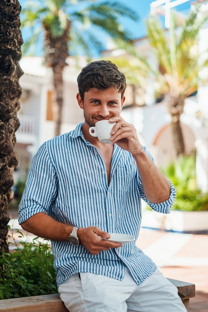 Uomo felice che beve caffè al mattino