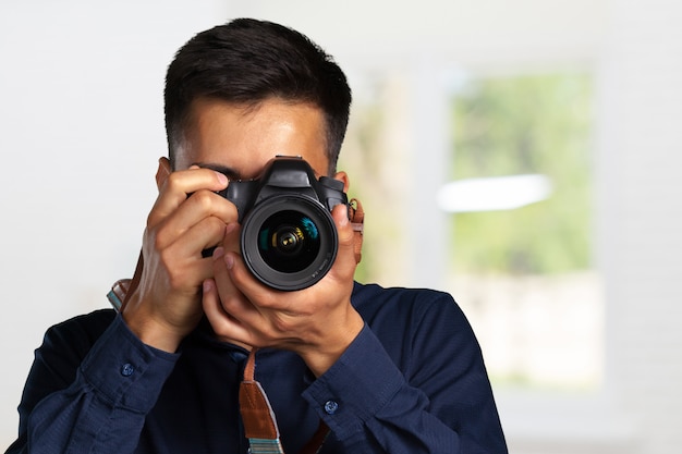 Uomo felice che cattura le maschere con la macchina fotografica digitale