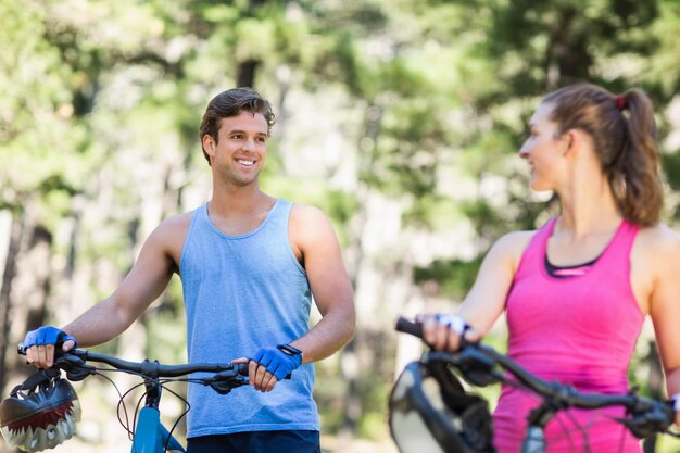 Uomo felice che esamina donna con le biciclette