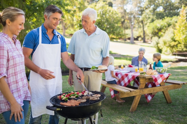 Uomo felice che fa barbecue per la sua famiglia