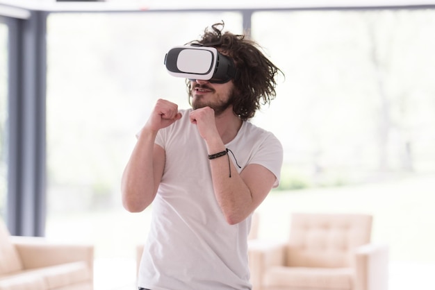 uomo felice che fa esperienza usando gli occhiali VR-auricolare della realtà virtuale a casa