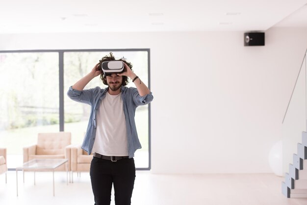 uomo felice che fa esperienza usando gli occhiali VR-auricolare della realtà virtuale a casa