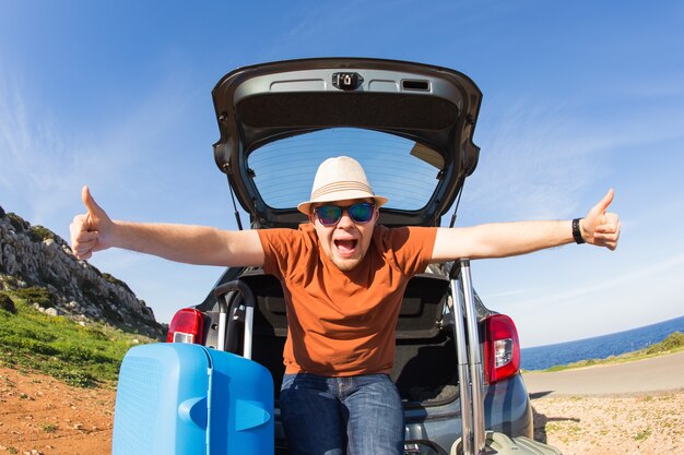 Uomo felice che gode del viaggio su strada e delle vacanze estive. Concetto di viaggio, vacanze e persone