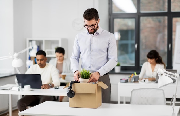 Uomo felice che lavora in un ufficio con cose personali.